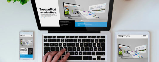 hand using a computer alongside a tablet and mobile phone to create a website reposted by Pixel Profiles
